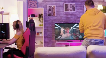 Casal jogando video-game em dispositivos diferentes