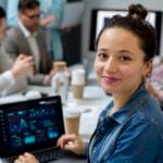 mulher trabalhando em notbook olhando para a câmera