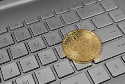 Moeda de bitcoin sobre o teclado de um notebook